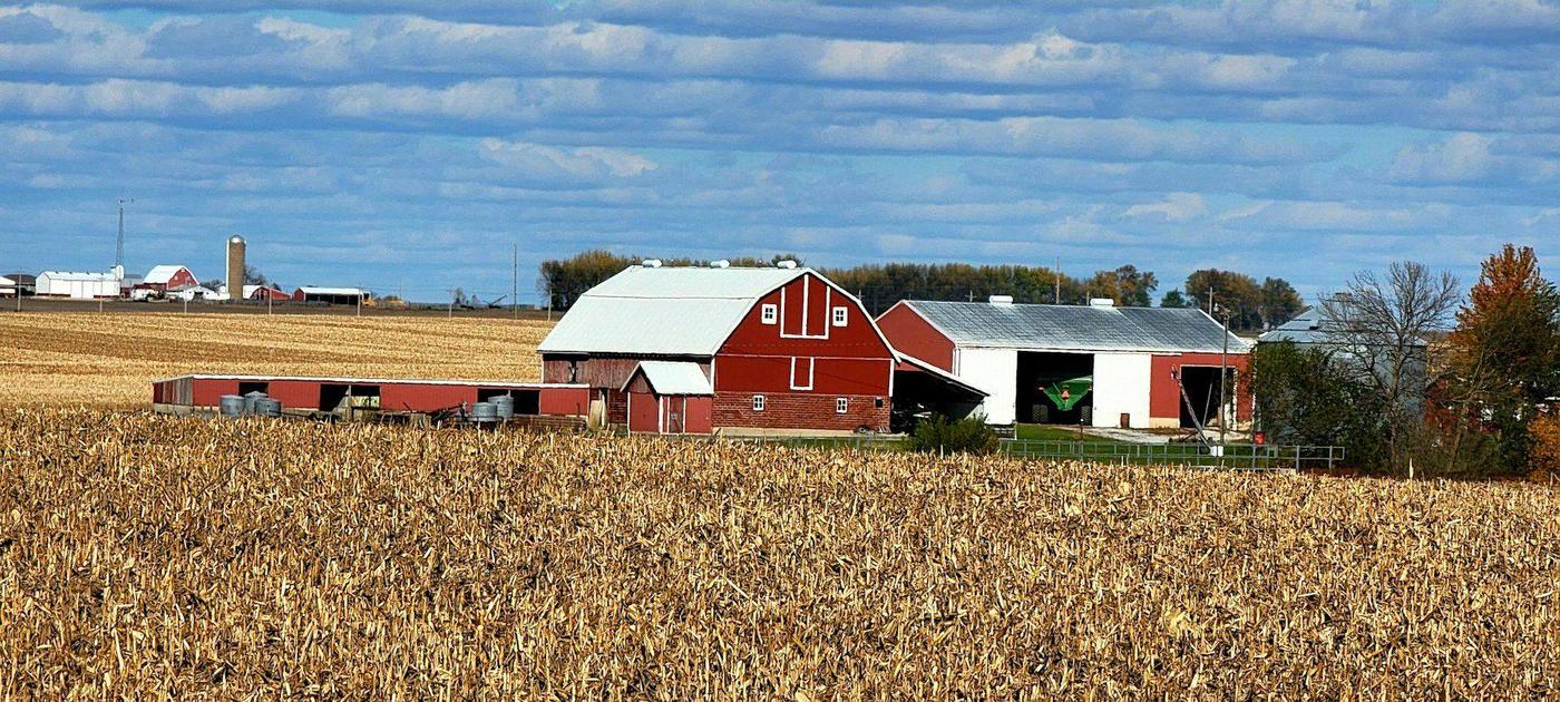 A red barn beside a harvested cornfield in rural Iowa.